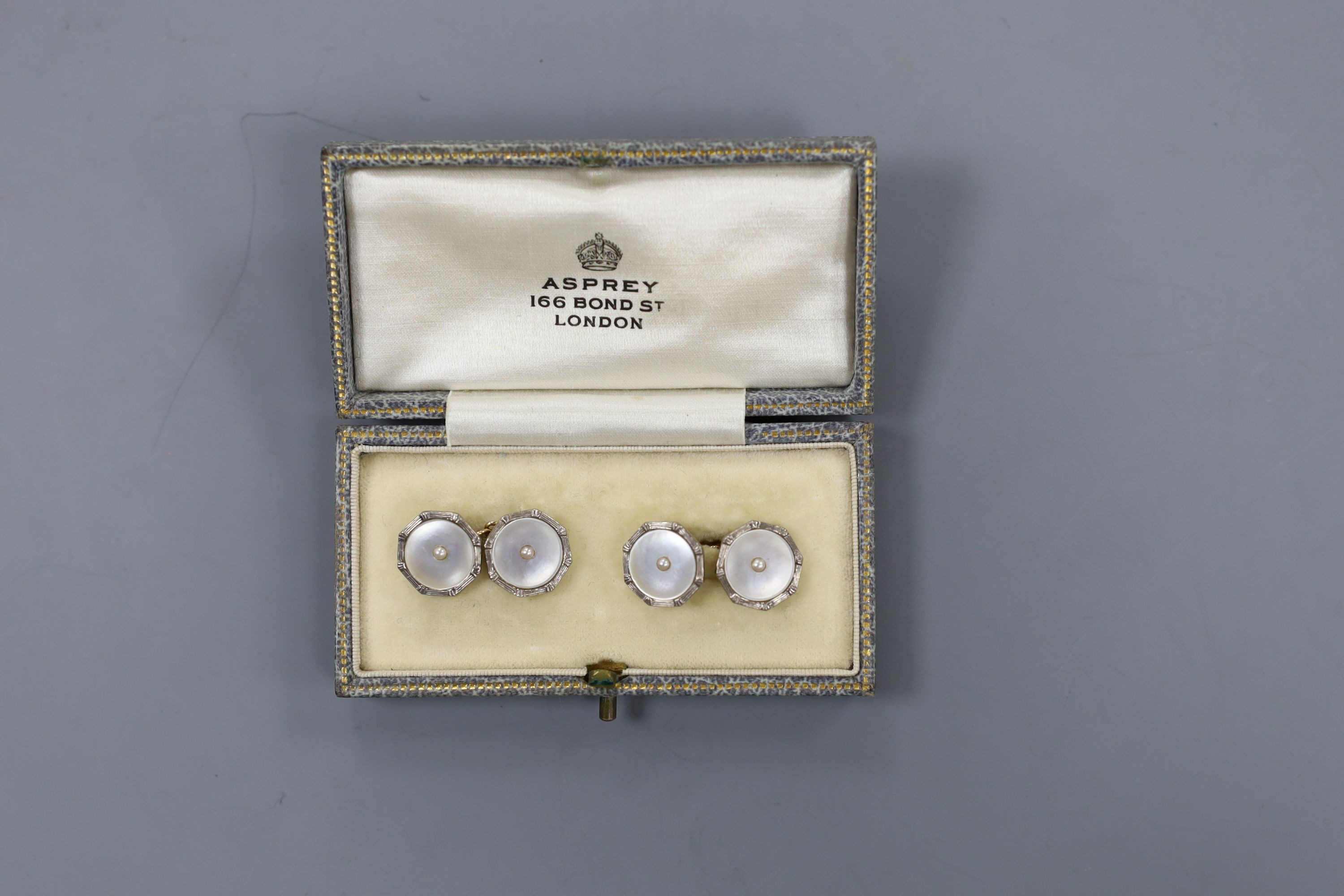 A cased pair of 18ct, 9ct, mother of pear and seed pearl set circular cufflinks, 13mm, gross weight 4.8 grams.